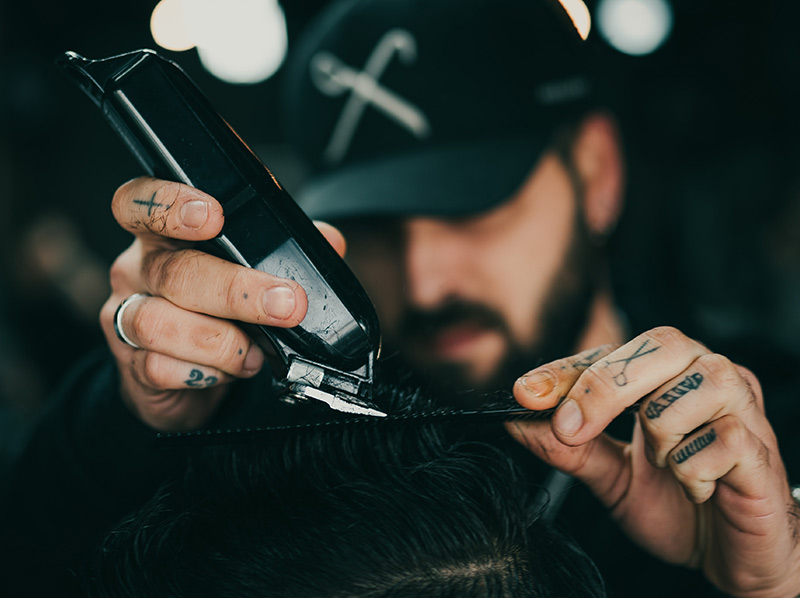 Barbier professionnel au travail dans le salon Bien Raser à Cannes